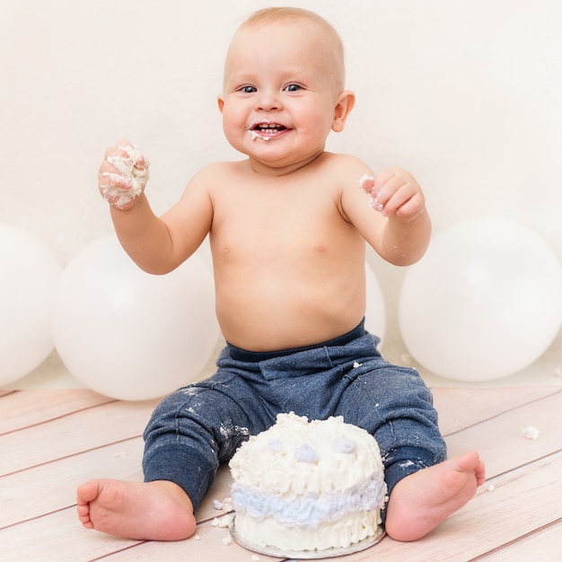 One year baby birthday party. Baby eating birthday cake. Cake smash