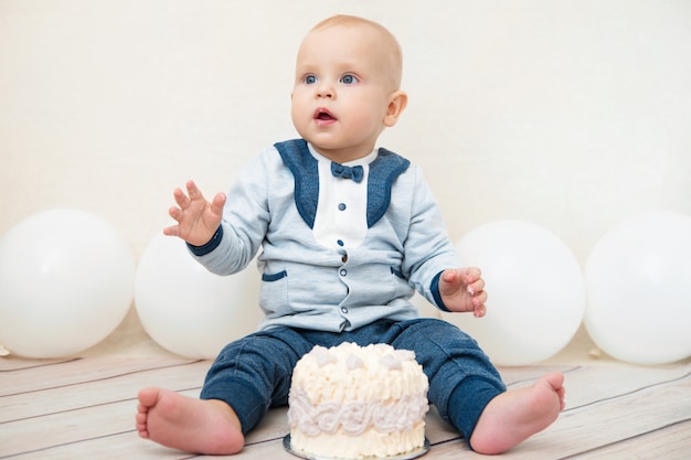 One year baby birthday party. Baby eating birthday cake.