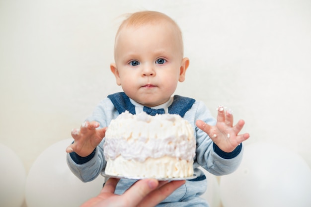 One year baby birthday party. Baby eating birthday cake