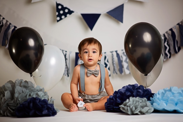 One-year-old cute boy on a gray background