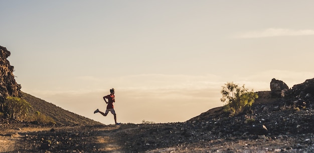 One young man running alone in the mountains and on the ground to be healthy and active