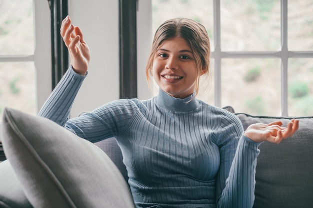 One young woman talking to the camera in a conference video call online with friends having fun and enjoying free time Student talking with class from home