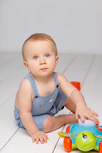 Oneyearold baby plays with cubes in the apartment white background