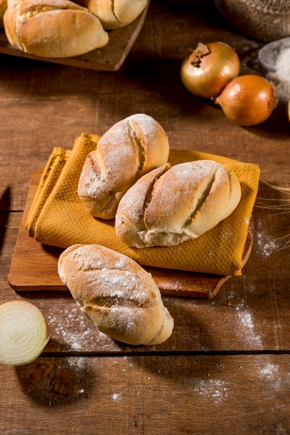 onion bread on rustic wooden table with other breads onions and flour in the background