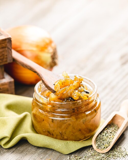 Onion jam in a glass jar on a wooden table