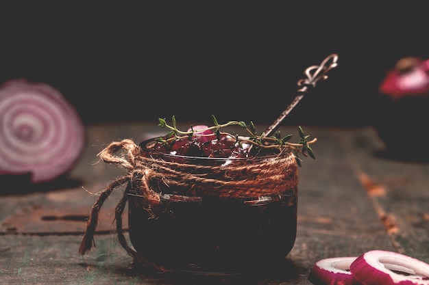 Onion jam marmalade jam confiture chutney on wooden table with wine and thyme banner menu recipe place for text