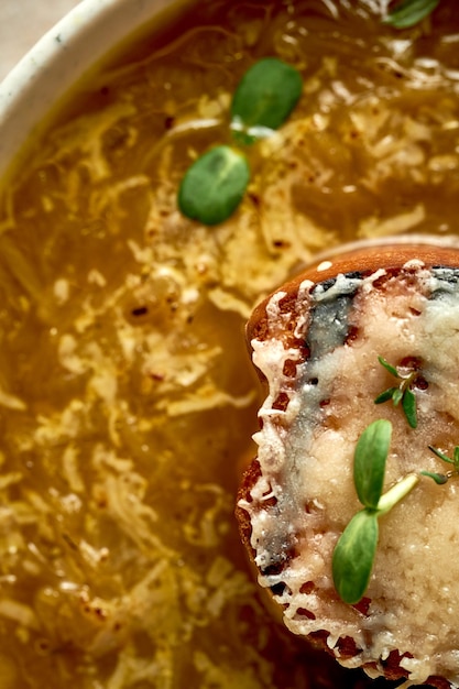 Onion soup with crouton in a bowl A selective trick Closeup French cuisine