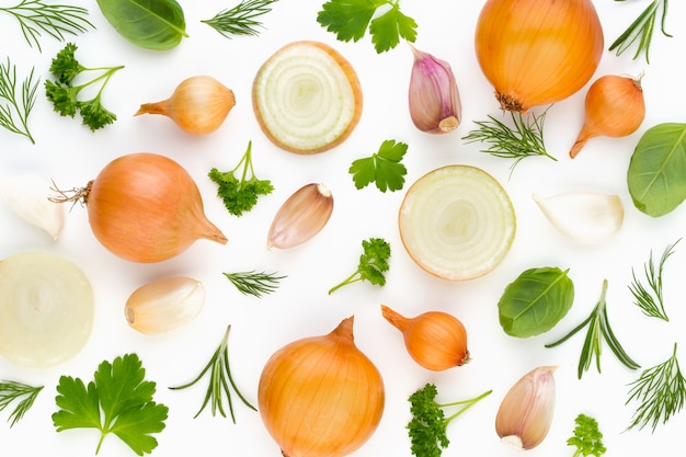 Onion and spices isolated on white background, top view. Wallpaper abstract composition of vegetables.