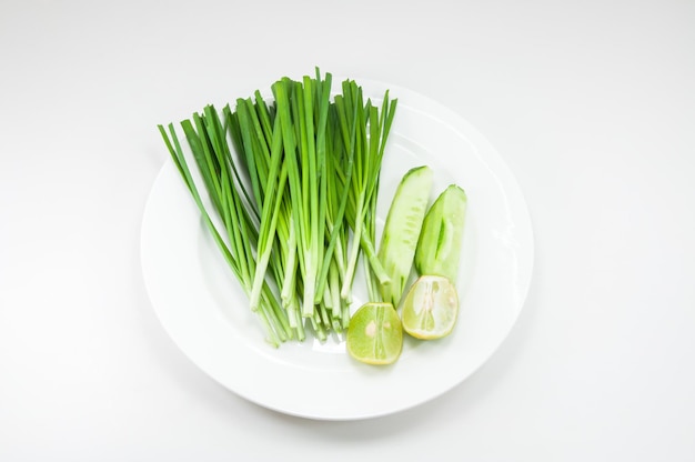 Onions lemon cucumber on white dish on white background