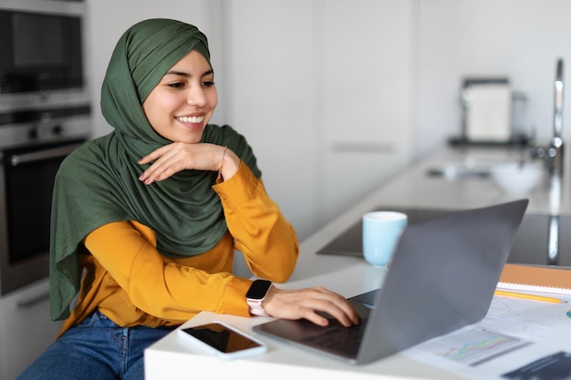 Online Business Young Muslim Woman In Hijab Working With Laptop At Home