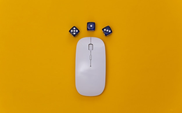 Online casino. Pc mouse and dice on a yellow background. Top view