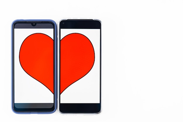 Online dating concept. Halves of the heart on the two smartphones screens. Valentine's Day concept