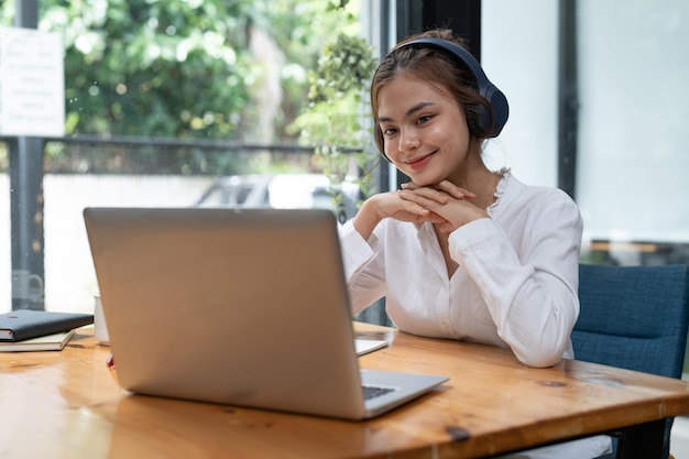 Online education elearning young woman studying remotely using a laptop listening to online webinar at home