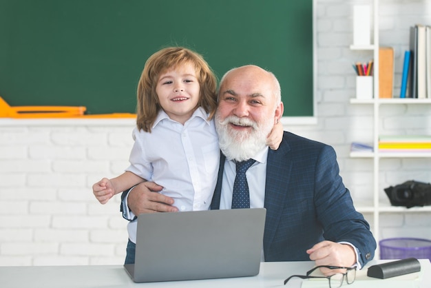 Online education Teacher with pupil in classroom Child with laptop Kid is learning in class with sen