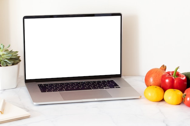 Online Food delivery concept with white blank screen laptop. Grocery delivery service. Home office.