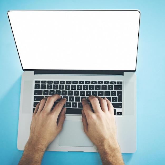 Online is where its all happening Studio shot of a man typing on a laptop with a blank screen against a blue background