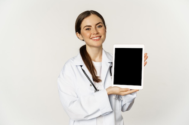 Online medical help remote appointment smiling beautiful woman doctor showing digital tablet screen ...