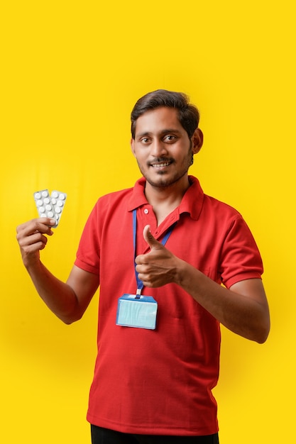 Online medicine concept : Indian delivery man holding medicine strip in hand