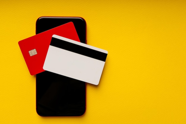 Online payment or banking concept Credit cards and smartphone on yellow background