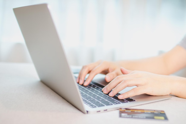 Online payment concept. A credit card and hand typing keyboard on laptop for online shopping.