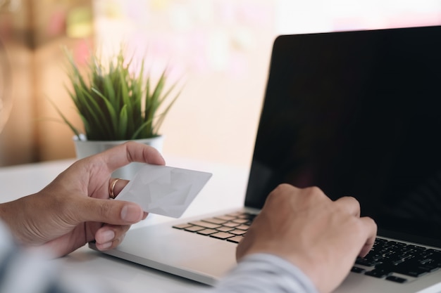 Online payment, Man's hands holding smartphone and using credit card for online shopping.