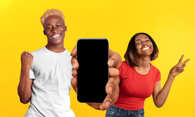 Online Sale Cheerful Black Couple Celebrating Success With Big Blank Smartphone