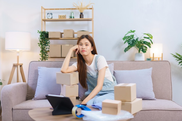 Online seller concept Female entrepreneur feel exhausted after packing product in box for shipping