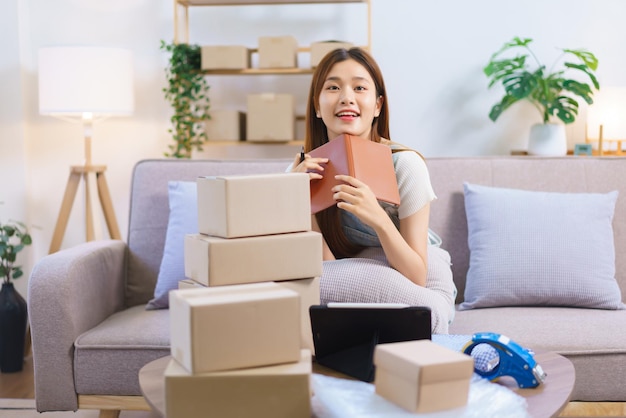 Online shopping concept Female entrepreneur relaxes after packaging product into parcel boxes