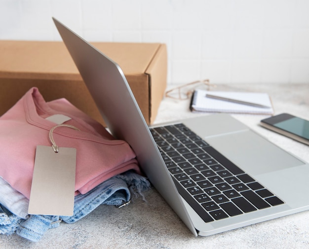 Online shopping concept. A laptop and a set of women's clothing in a cardboard box. Delivery of clothes.