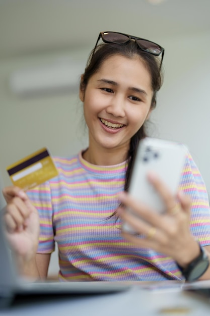 Online Shopping and Internet Payments Portrait of Beautiful Asian women are using their credit cards and mobile phones to shop online or conduct errands in the digital world