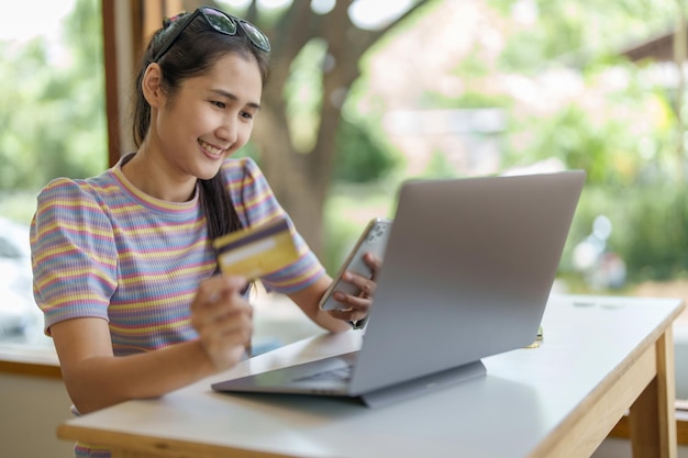 Online Shopping and Internet Payments Portrait of Beautiful Asian women are using their credit cards and mobile phones to shop online or conduct errands in the digital world