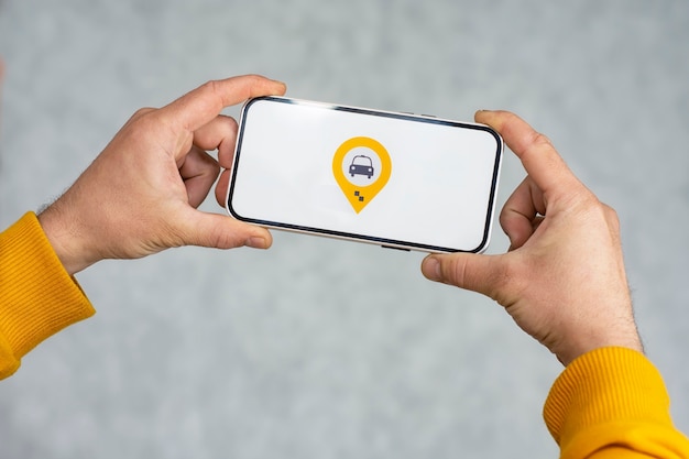 Online taxi on your phone. A man holds a smartphone with a white screen and a geolocation and location icon for a taxi.