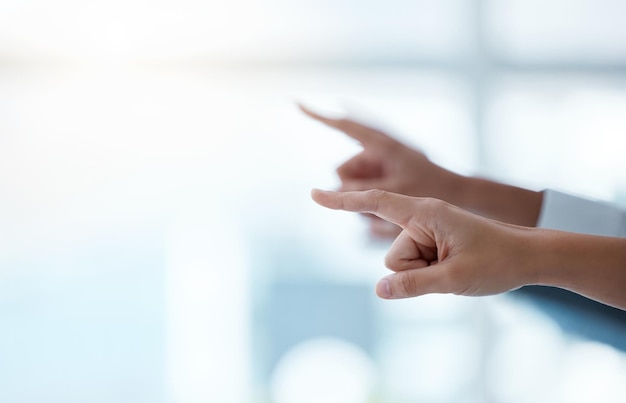 The only way is up. Shot of a group of unrecognisable businesspeople pointing during a meeting in a modern office.