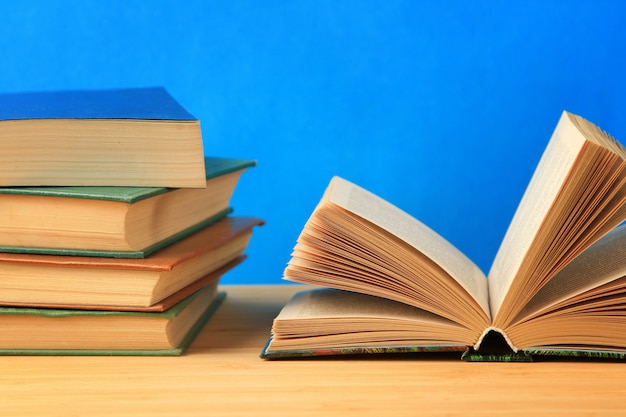 Open antique book on wooden table on wall