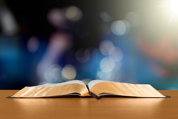 Open Bible on a wood table with light coming from above. ( Church concept. )