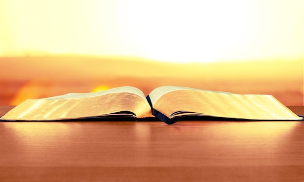 Open book on old wooden table.