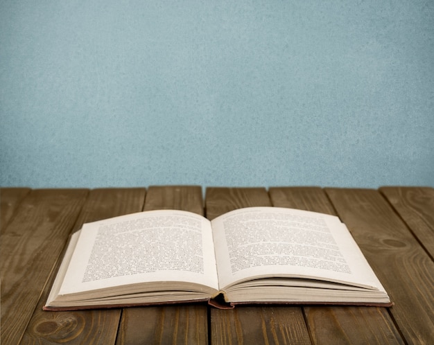 Open book on old wooden table.