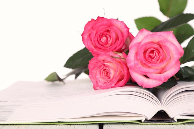 Open book with beautiful roses isolated on white