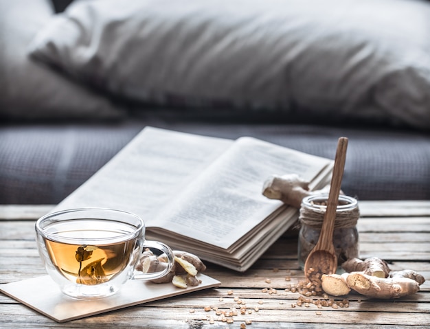 open book with cup of tea on wooden table