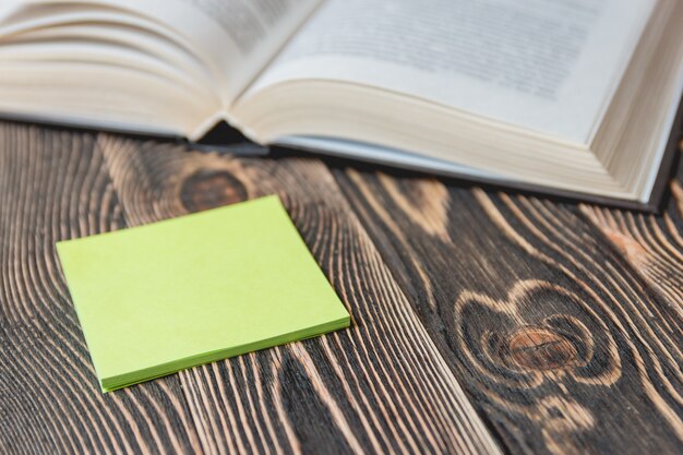 Open Book on Wooden Desk with Autumn Leaves Close up.