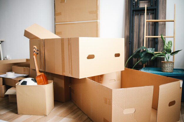 Photo open cardboard logistic boxes with housing stuff messy containers placed on floor of new home