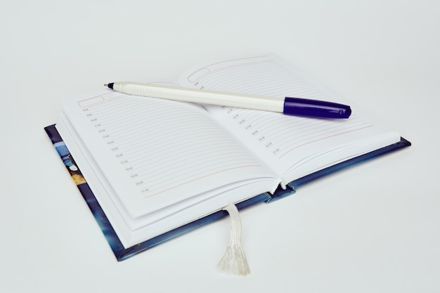 Open diary with ballpoint pen