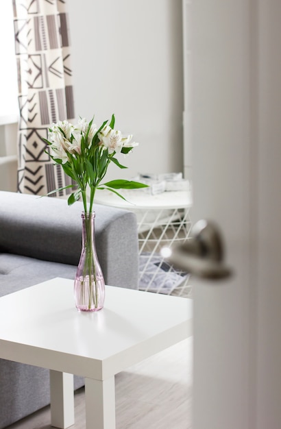 Open door to room with bouquet of flowers on table, Scandinavian interior