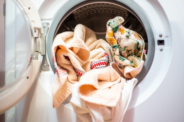 Open door of the washing machine with linen