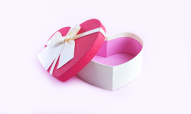 Photo open empty heart shape gift box with ribbon bow on pink table