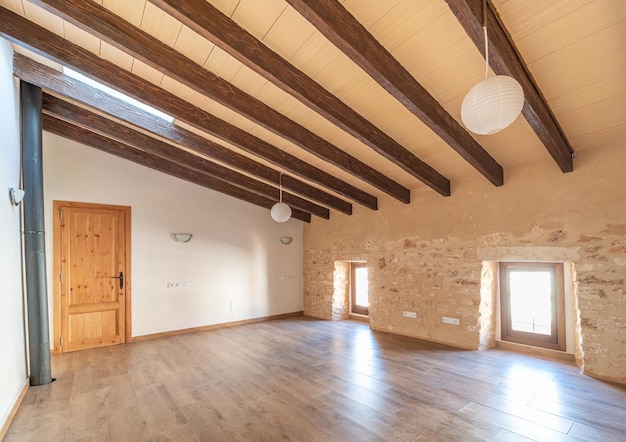 Open empty master bedroom with parquet floors, wooden beams and air conditioning in rustic style