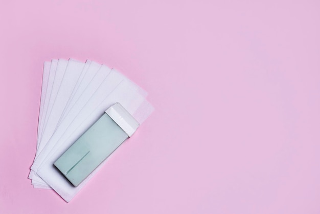 An open fan and a lighter on a pink background