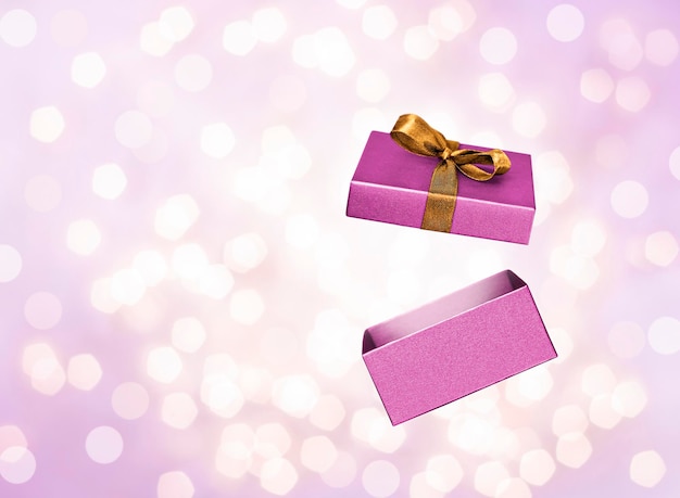 open gift box on purple background with bokeh closeup