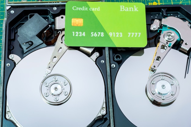 Photo open hard disk drive with credit card. information, data storage infrastructure cost concept