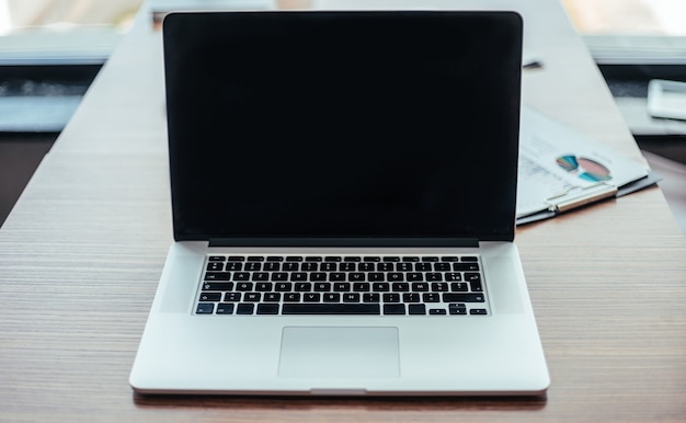 open laptop and financial chart on the Desk in the office